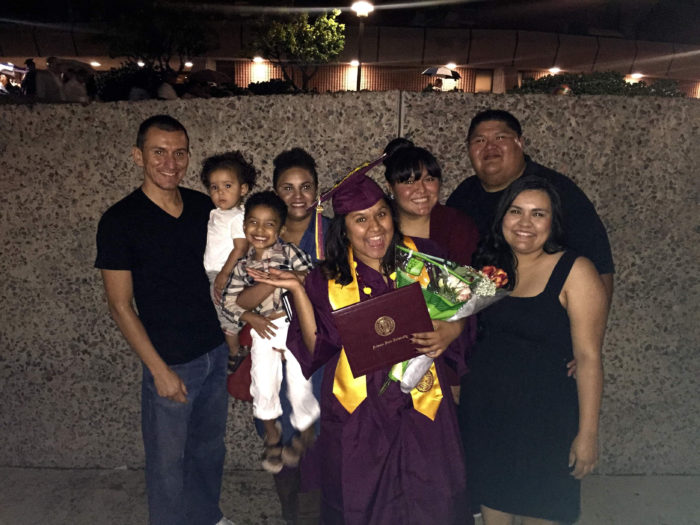 A group of family members surround an ASU graduate 