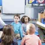 Group of young children in a circle with their teachers